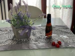 蒙特西尔瓦诺Oasi Verde appartamento的一瓶葡萄酒和花卉及浆果花瓶