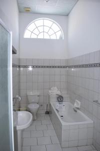 奥马鲁鲁Central Hotel Omaruru的白色的浴室设有卫生间、浴缸和水槽。