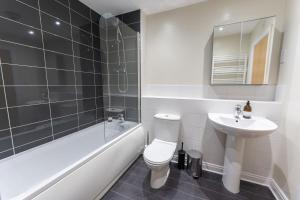 伯明翰JOIVY Modern flats in central Birmingham, next to business district的浴室配有卫生间、盥洗盆和浴缸。