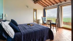 阿夏诺Agriturismo Le Crete - Appartamenti的卧室配有一张床和一张桌子及椅子