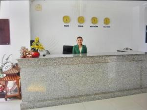 胡志明市Phung Long Hotel的站在柜台后面的女人