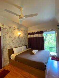 Ban Muang Ton Mamuang三M山区度假酒店的一间卧室配有一张带吊扇的床