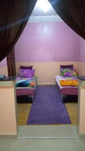 达赫拉DAKHLA的紫色墙壁客房的两张床