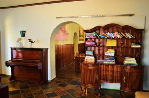 奥马鲁鲁Central Hotel Omaruru的一间设有两个木制书架和钢琴的房间