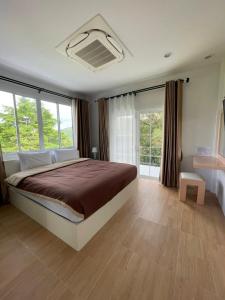 Ban Muang Ton Mamuang三M山区度假酒店的一间卧室设有一张大床,部分设有窗户。