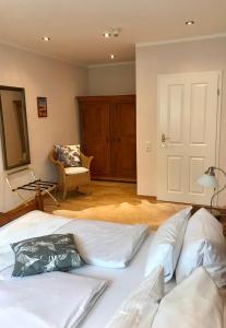 杜塞尔多夫古特莫斯科恩霍夫酒店的一间卧室配有一张带白色床单和椅子的床