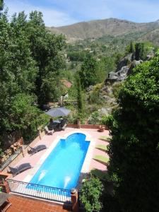 格拉纳达Cortijo La Mata的大型蓝色游泳池,享有山景