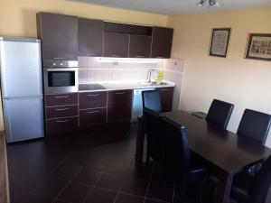 波德戈里察Apartment Filipovic的厨房配有桌子和白色冰箱。