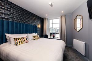 都柏林渡船夫酒店的一间卧室配有一张白色大床和蓝色的墙壁