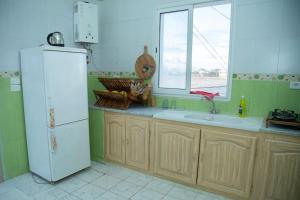 托泽尔Dar Beya ( APP S+2 )的厨房配有白色冰箱和窗户。