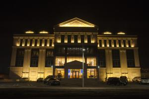 乌兰巴托索约尔酒店的一座大型建筑,晚上停在大楼前面