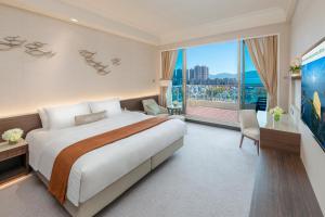 香港香港黄金海岸酒店的一间卧室设有一张大床和一个大窗户