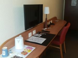 Amilly基里亚德蒙塔基艾米丽酒店的一张桌子,放在一间酒店的房间,里面配有电视