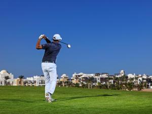 赫尔格达Ancient Sands Golf Resort and Residences的一个人在高尔夫球场打高尔夫
