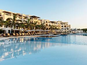 塞拉莱法纳尔酒店及公寓的一座带椅子和棕榈树的大型游泳池以及大楼