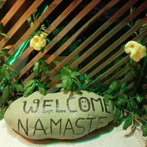 索拉哈Shiva's Hippies Colony的植物旁的欢迎用纳马提尔标志