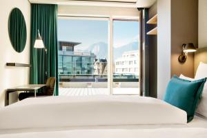 因斯布鲁克Motel One Innsbruck的一间卧室设有一张床和一个大窗户