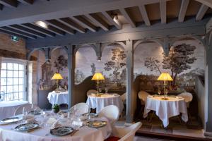 特雷莫拉长者之家酒店的用餐室配有桌椅和壁画