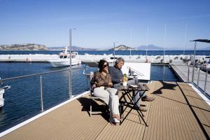 普罗奇达ALMALO Floating House - Casa Galleggiante的坐在船甲板上的男女