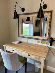 克劳利科蒂斯莫尔酒店&高尔夫乡村俱乐部 的一张带镜子和椅子的木桌