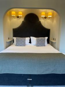 克劳利科蒂斯莫尔酒店&高尔夫乡村俱乐部 的一间卧室配有一张大床和大床头板