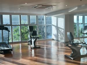 马尼拉Uptown Parksuites II的一个带跑步机和健身器材的健身房,位于带窗户的房间