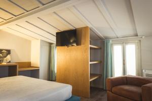 维杰瓦诺皮卡罗托雷旅馆的一间卧室配有一张床,并在橱柜上配有电视
