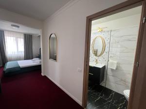 布加勒斯特Eden Boutique Accommodation的酒店客房设有带一张床和镜子的浴室