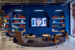 图卢兹The Social Hub Toulouse的图书馆拥有蓝色的墙壁和椅子,书架