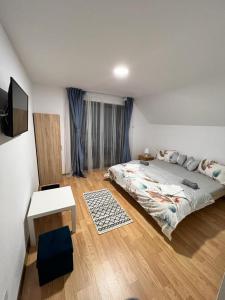 ŞurdeştiPensiunea RNB Maramures的一间卧室配有一张床、一张桌子和一台电视