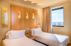马德里阿巴马德里酒店的配有窗户的酒店客房内的两张床