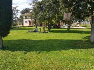 布鲁法Casale in collina vista Assisi,Brufa di Torgiano的公园配有两把椅子和秋千
