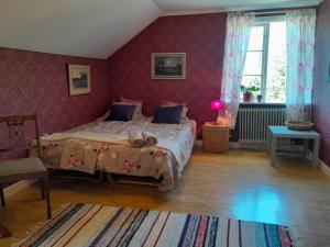 UrshultKurrebo的一间卧室设有一张紫色墙壁的大床