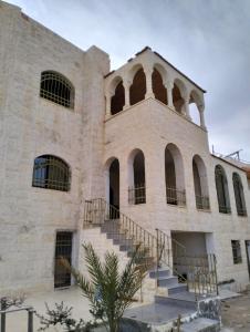 瓦迪穆萨Twilight Hotel Petra的一座古老的石头建筑,前面设有楼梯