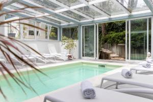 埃斯特角城AWA精品设计酒店的一个带玻璃天花板温室的游泳池