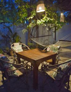 布韦朱Maryam Garden Apartments & Villa的一张木桌、两把椅子和吊床