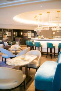 奥斯陆大陆酒店的一间带桌椅的餐厅和一间酒吧
