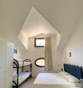 里奥马里纳贝伦妮丝公寓的一间卧室设有两张双层床和一扇窗户。