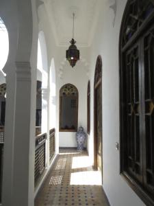丹吉尔阿鲁斯卡梅尔摩洛哥传统庭院旅馆的走廊上,房子的地板上有一个花瓶