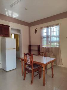 PortsmouthIso’s Vacation Rental Apartment #8的厨房配有桌子和白色冰箱。