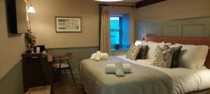 科尼斯顿皇冠客栈的酒店客房设有两张床、一张书桌和一个窗户。