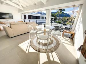 Anse Marcel Acacia Tropical, luxurious Duplex, walkable beach的阳台设有带桌椅的客厅