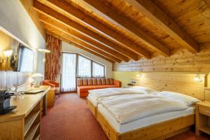 采尔马特阿尔彭皇家酒店的木制客房内的一间卧室配有一张大床
