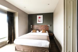 奥尔良赛德赖斯酒店的一间卧室设有一张带砖墙的大床