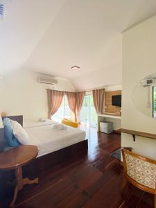 北碧ชอว์ งาทอง รีสอร์ต Chor Ngar Thong Erawan的卧室配有一张床和一张桌子