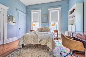 小石城Historic Home Near Downtown Little Rock!的卧室拥有蓝色的墙壁,配有一张床和椅子