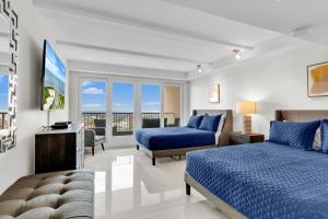 南帕诸岛Panoramic Island View! NEW 1 BR spacious condo in beachfront resort的酒店客房设有两张床和电视。