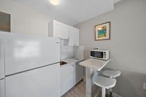 沃思湖Capri Inn & Apartments的厨房配有白色冰箱和微波炉
