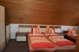 奥尔斯贝格菲利恩豪斯梅德巴赫酒店的配有木天花板的客房设有两张床。