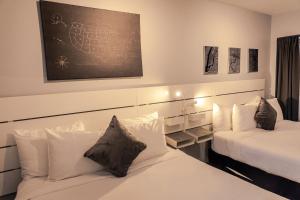 迈阿密Up Midtown的卧室配有两张床,墙上设有一张黑板